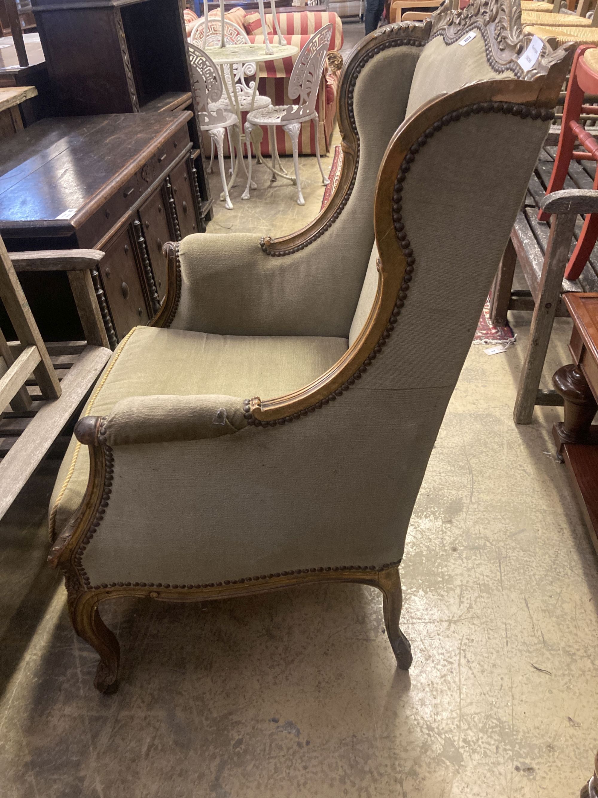 An early 20th century French parcel gilt carved beech wing armchair, width 70cm, depth 66cm, height 115cm